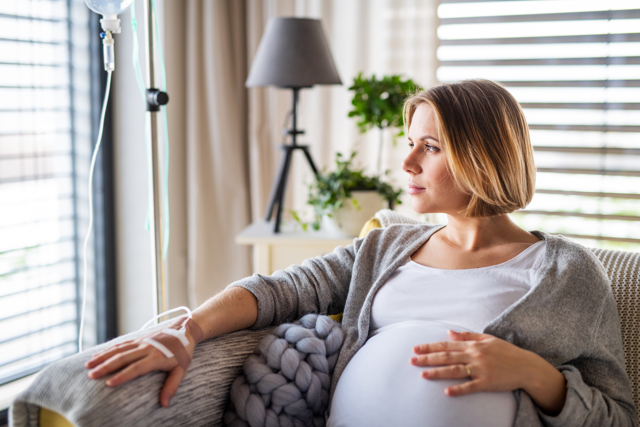 Pregnant woman receiving mobile IV hydration therapy at home from a registered nurse